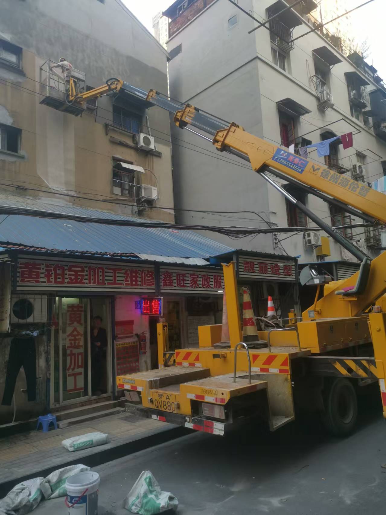 22米登高車載人粉刷外墻施工現場